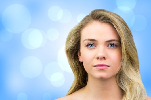 Serious blonde natural beauty against blue abstract light spot design