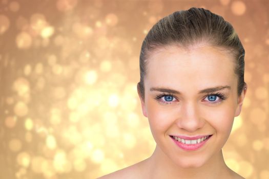 Smiling blonde natural beauty against yellow abstract light spot design