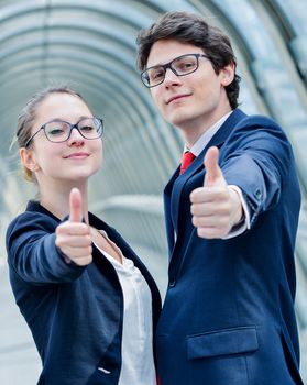 expressive portrait of junior executives of company thumb up