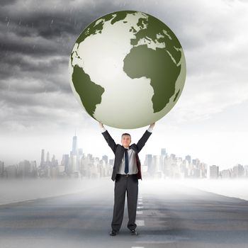 Composite image of businessman holding earth against open road