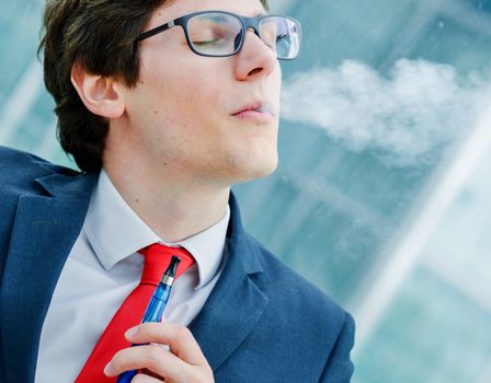  Portrait of cheerful man smoking with e-cigarette outdoor