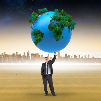 Composite image of businessman holding earth against cityscape on the horizon