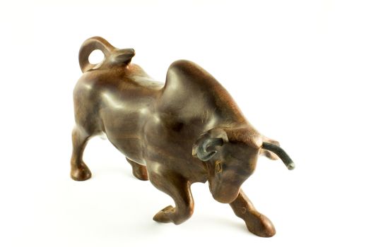 the wooden figurine of a bull on a white background