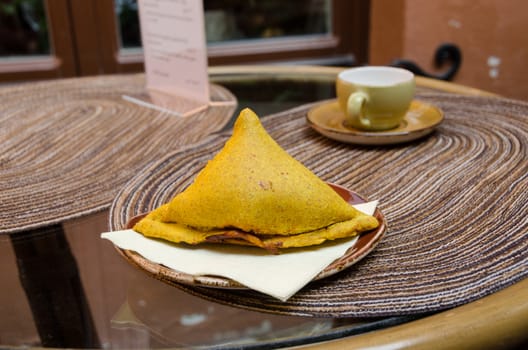 Indian vegetarian cooking patty with vegetables in small clay plate on table outdoors