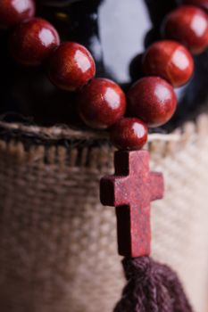 wooden rosary with a cross on a bottle of wine
