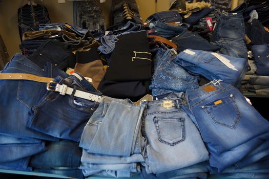 heap of jeans in small jeans store