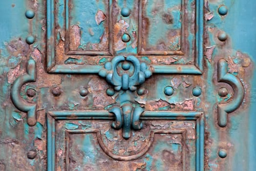 Ornate rusty iron gate close detail.