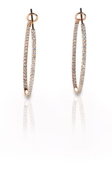 Pierced diamond hoop earrings in rose gold isolated on a white background with reflection