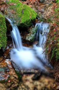 Detail of small waterfall on mossy rock.