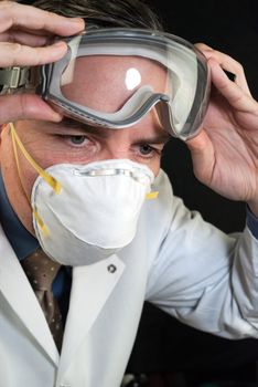 Close-up of a Doctor wearing a mask and putting on goggles.