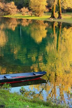 Boat at Crnojevica river with colorful trees reflection, Montenegro, Balkans