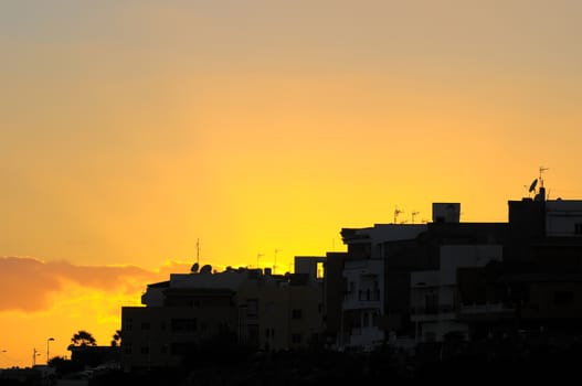 Silhouettes of Houses at Sunset over a Sea Village