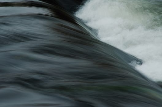 Dark water wave on the river with lot of foam.