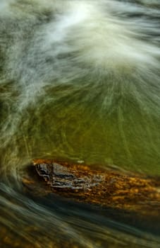 Dark water wave on the river with lot of foam.