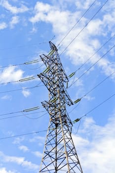 High Voltage Power Lines And Large Pylon Above Blue Sky