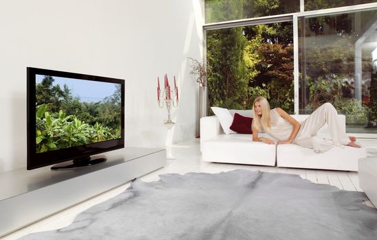 beautiful blonde woman watching TV at home