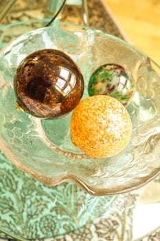 Some decorative Christmas Spheres in a glass bowl.
