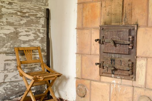 two closed old retro rustic furnace doors with handle and wooden rest chair