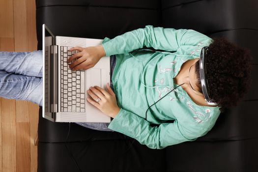 A young, brazilian woman surfing on the Internet with a Laptop.  
