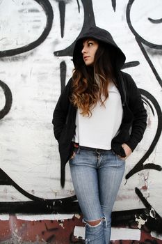 A young woman leaning on a wall.