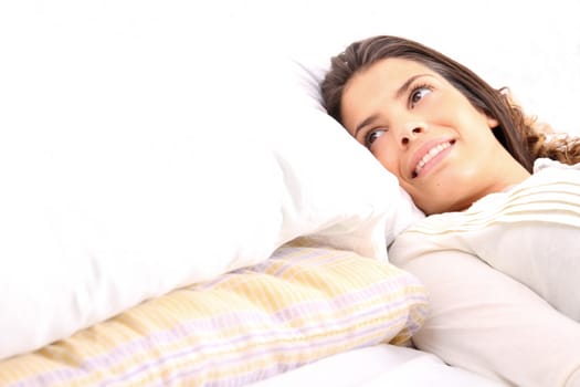 A young girl laying in bed and smiling

