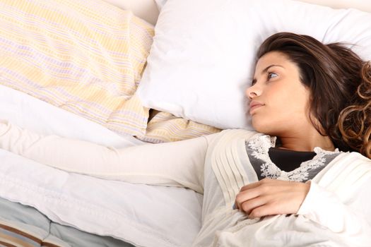 A woman lying alone on the bed.