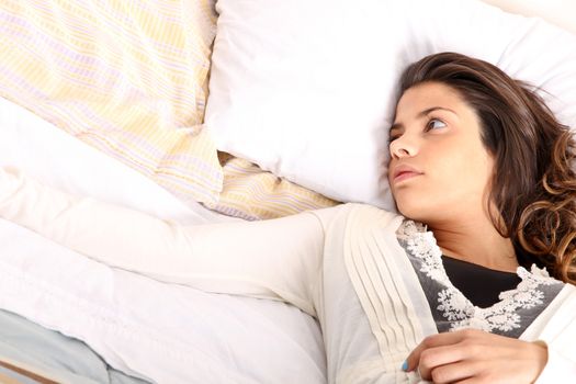 A woman lying alone on the bed.