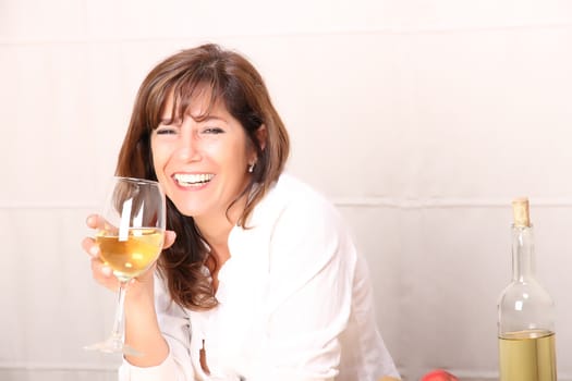 A beautiful mature woman with a glass of white wine.