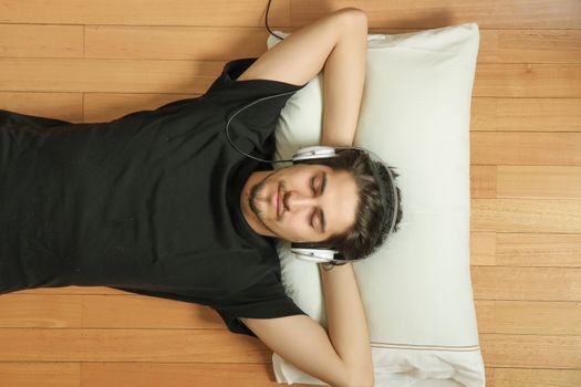 A young hispanic man listening Music with headphones.