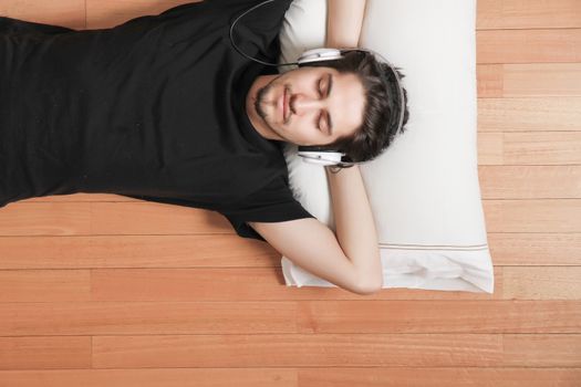 A young hispanic man listening Music with headphones.