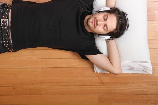 A young hispanic man listening Music with headphones.