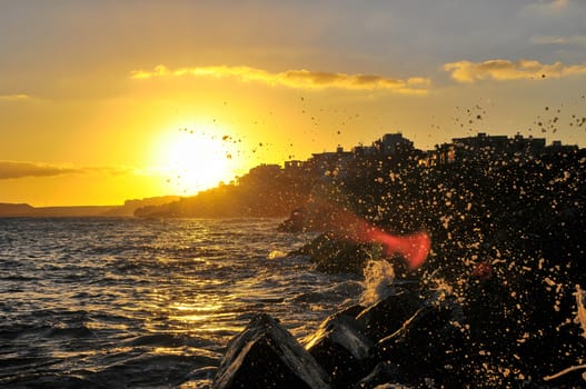 Silhouettes of Houses at Sunset over a Sea Village