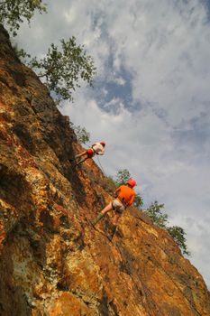 rock climber climbing an overhanging cliff against the blue sky