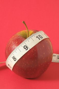 Measuring Tape Wrapped Around Red Apple as a Symbol of Diet