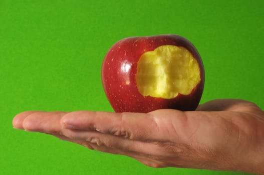 Bitten Red Apple Hand on a Colred Background