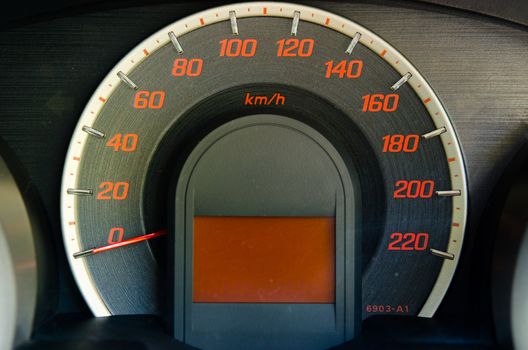 Close up of car dashboard with speed and rpm dials.