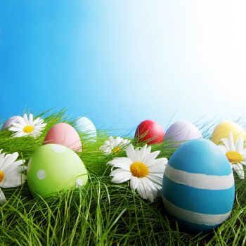 Easter Greeting Card with decorated eggs in the grass and flowers
