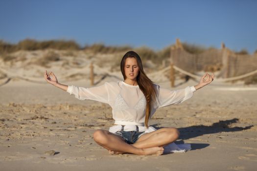 woman doing yoga on a beach
