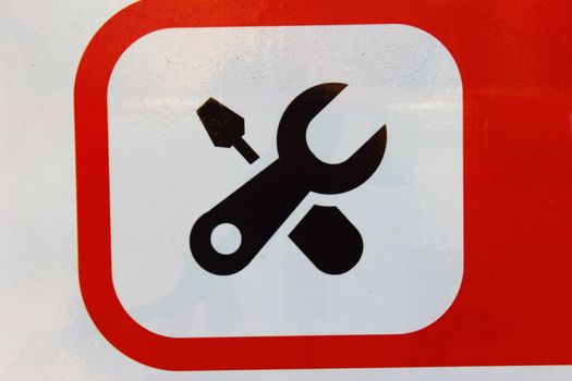 On a white background in a red frame in the form of a wrench and screwdriver icon "servicing"