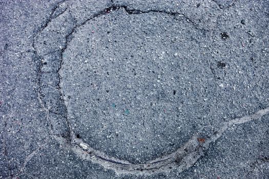 Manhole with the cover completely paved with asphalt