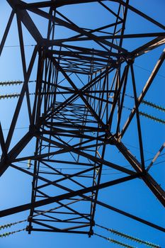 Electricity pylon against the blue sky background.