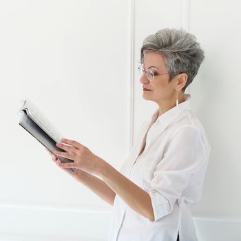 Elderly. Happy woman with magazine