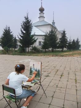 Woman painting church, Suzdal, Russia