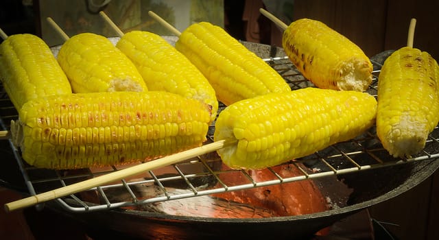The delicious yellow grilled corn on stove.