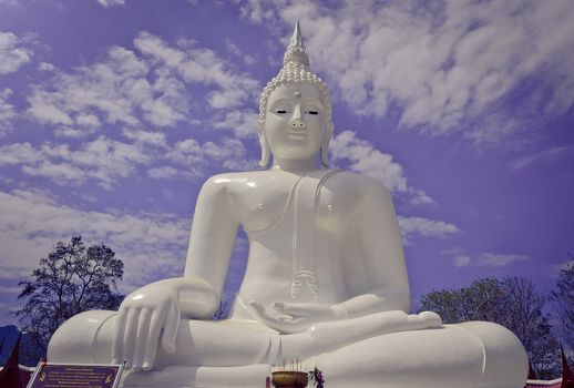 The white seated buddha image in Cloudy Blue Sky Background place at Wat Thatanon, Thongphapoom district, Kanchanaburi province, Thailand.
