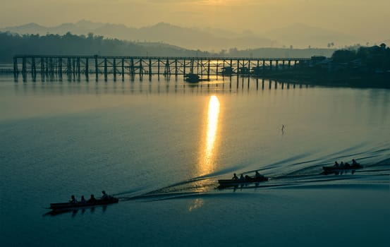 The simply life beside the wooden bridge on the lake in sunrise.