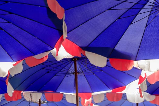 Beach umbrella a lot on the beach.