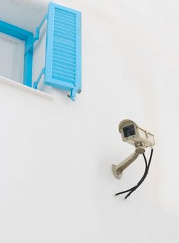 Surveillance Camera mounted on the white wall.