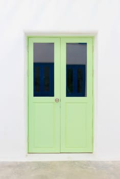 Green elegant entrance door with white wall.