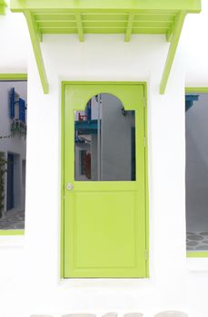 Green elegant entrance door with white wall.